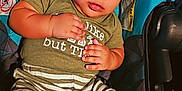 Mckayden joined the competition — help win amazing prizes! baby, child, car_seat, green_shirt, striped_pants, socks, curly_hair, indoors, cute, infant, young_child, seated, looking, closeup, portrait, fabric, pattern, hands, feet, comfort