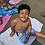 Taylin is registered to the contest to win money with this photo: child, boy, smiling, curly_hair, summer, towel, swim_shorts, outdoor, pavement, sunlight, happy, sitting, playful, friends, kids, bare_chested, recreation, daytime, relaxing, fun