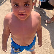 Taylin is registered to the contest to win money with this photo: child, boy, curly_hair, barefoot, swim_shorts, blue_shorts, outdoor, sunny, concrete, smiling, summer, playful, standing, casual, happy, person, daylight, skin, young, cute