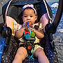 baby, child, car_seat, toy, headband, indoor, person, cute, infant, seatbelt, pink, black, socks, legs, face, holding, playful, young, comfort, home