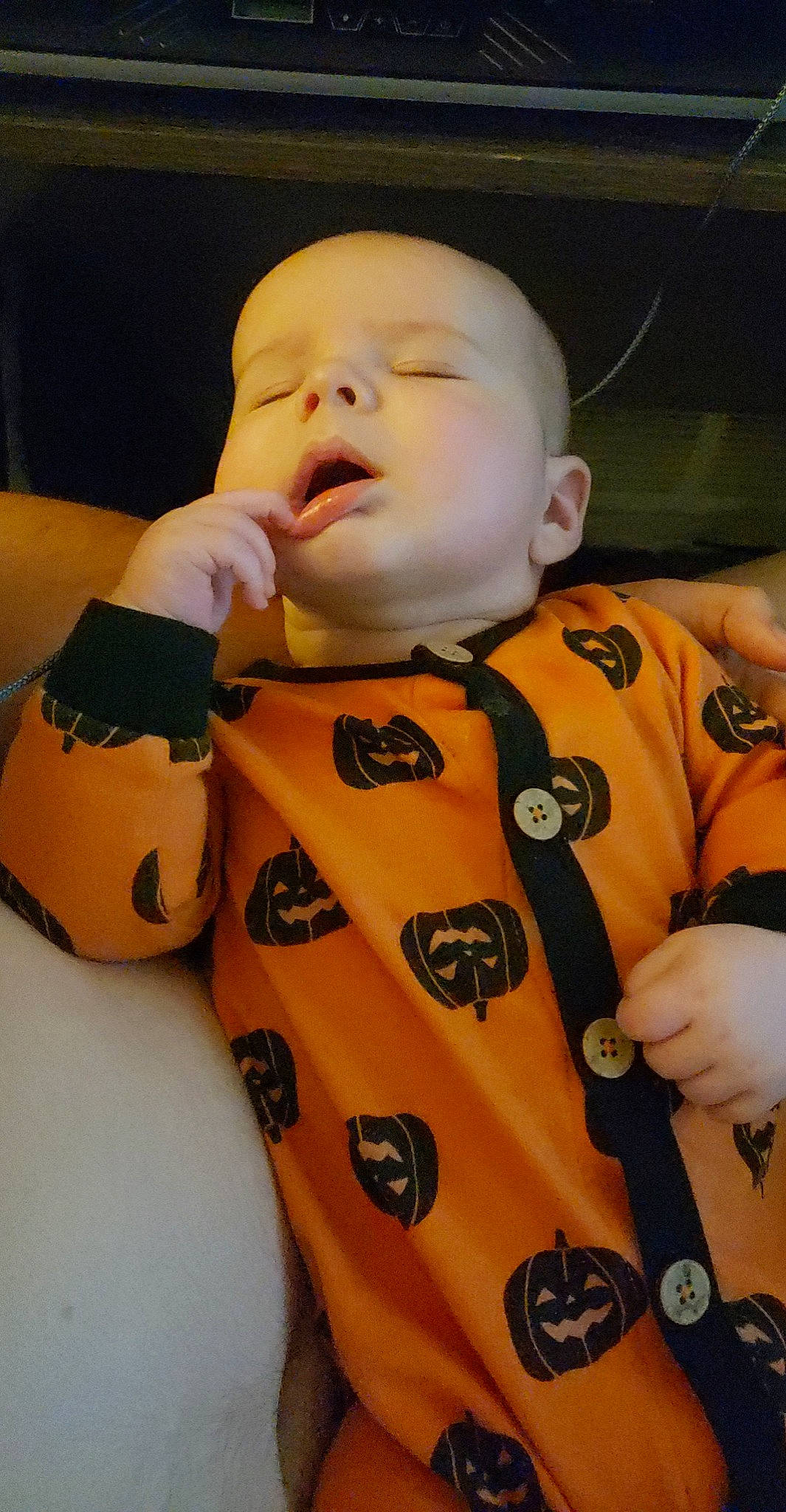 Atlas is registered to the contest to win money with this photo: arm, baby, cheek, chest, cool, finger, fun, gesture, hand, human_body, joint, mouth, nail, nose, orange, person, personal_protective_equipment, sitting, sleeve, thumb