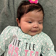 Catalina joined the competition — help win amazing prizes! baby, infant, child, smiling, face, hair_accessory, flower, blanket, clothing, onesie, text, lying_down, cute, portrait, young, soft_texture, sleepwear, pink, green, happy
