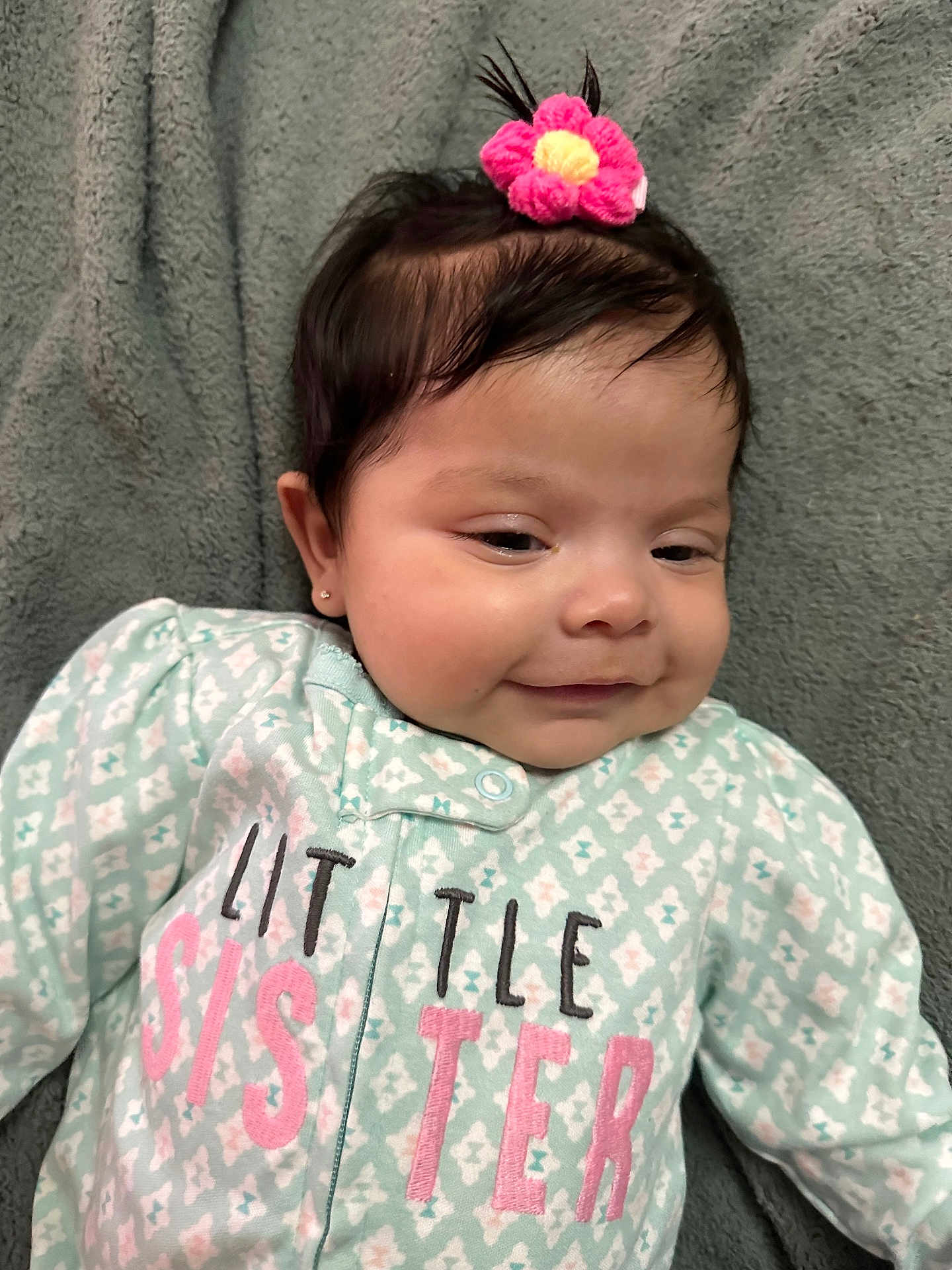 Catalina joined the competition — help win amazing prizes! baby, infant, child, smiling, face, hair_accessory, flower, blanket, clothing, onesie, text, lying_down, cute, portrait, young, soft_texture, sleepwear, pink, green, happy