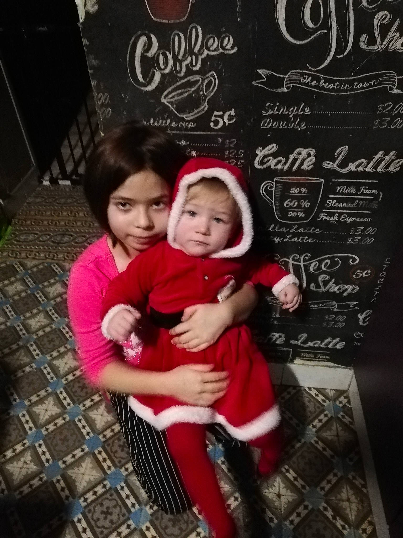 Noëlyne participe au concours pour gagner de l'argent avec cette photo : baby, baby_toddler_clothing, blackboard, chair, chalk, child, christmas_eve, event, flooring, font, fun, handwriting, happy, holiday, lap, pattern, person, room, sandal, sitting