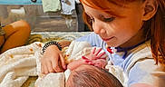 Kory-Lynne is registered to the contest to win money with this photo: child, newborn, baby, sibling, sister, red_hair, portrait, indoor, family, holding, blanket, cozy, smiling, infant, hands, playpen, bedroom, warm_lighting, caring, tender