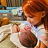 child, newborn, baby, sibling, sister, red_hair, portrait, indoor, family, holding, blanket, cozy, smiling, infant, hands, playpen, bedroom, warm_lighting, caring, tender