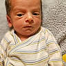 Ricky joined the competition — help win amazing prizes! newborn, baby, infant, child, portrait, face, eyes, looking_at_camera, striped_onesie, clothing, lying_down, blanket, couch, indoors, close_up, head, skin, brown_hair, cozy, photograph
