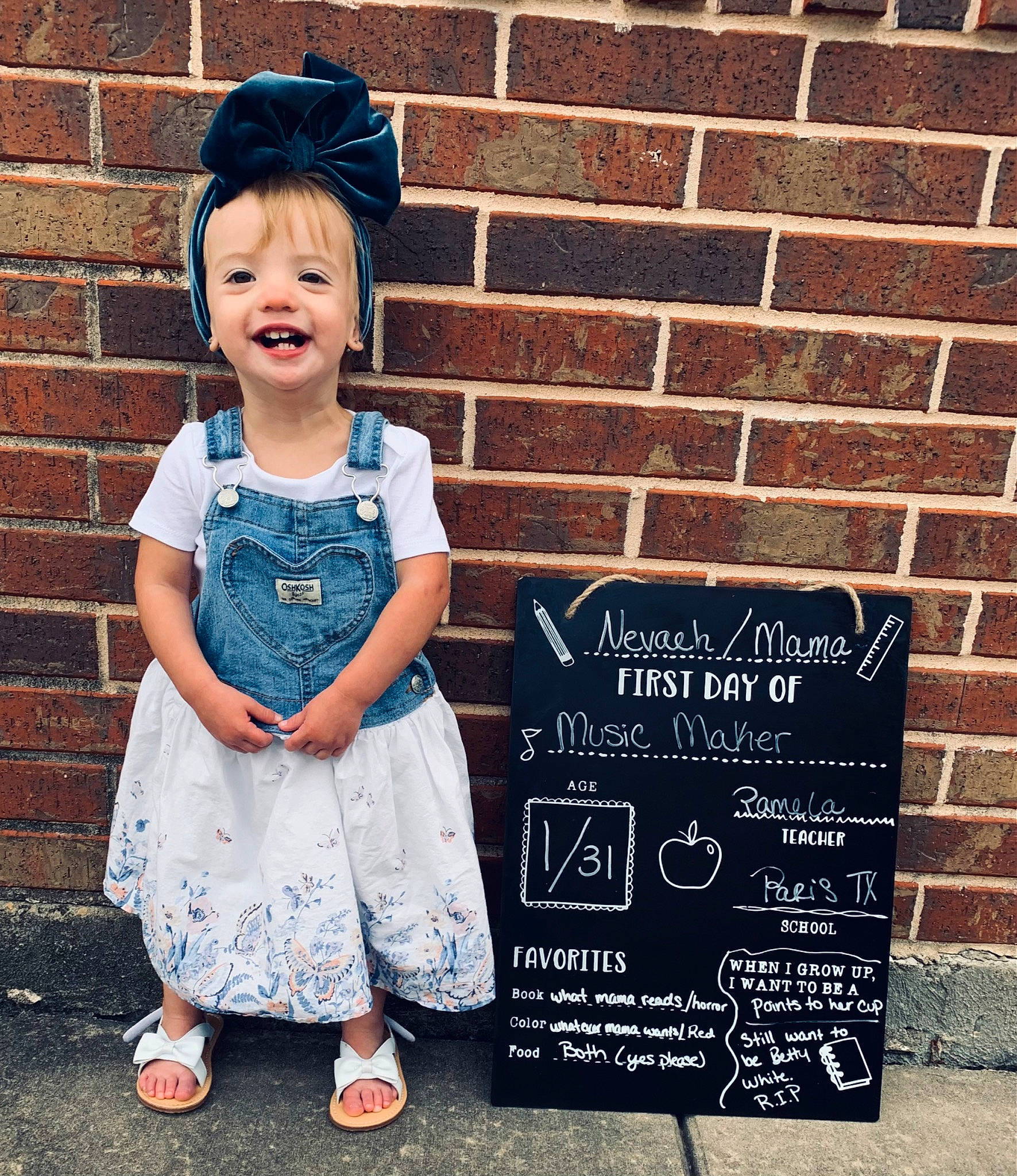 Nevaeh is registered to the contest to win money with this photo: baby_toddler_clothing, blue, brick, brickwork, chalk, child, cool, electric_blue, fashion_accessory, font, handwriting, happy, hat, joy, pattern, person, sandal, sleeve, smile, standing