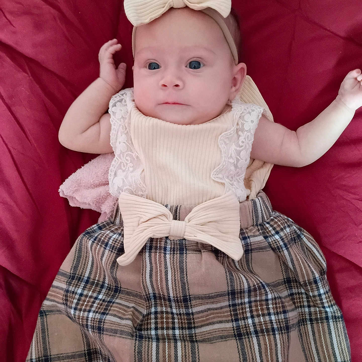 Jaimalyn joined the competition — help win amazing prizes! arm, baby, bow, child, clothing, cute, dress, fabric, face, hand, headband, indoors, infant, lying_down, person, plaid_skirt, portrait, red_blanket, soft_texture, young