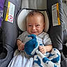 baby, blanket, blue, car_seat, child, clothing, comfort, cozy, cute, indoor, infant, pattern, person, plush_toy, portrait, sitting, smile, toy, white, wood_floor