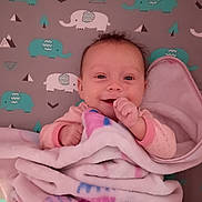 Jaimalyn is registered to the contest to win money with this photo: baby, blanket, smile, infant, elephant_pattern, pink, cozy, cute, lying_down, child, face, hand, soft, comfort, bed, happy, wrapped, newborn, portrait, indoors