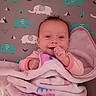 baby, blanket, smile, infant, elephant_pattern, pink, cozy, cute, lying_down, child, face, hand, soft, comfort, bed, happy, wrapped, newborn, portrait, indoors