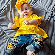 Jaimalyn is registered to the contest to win money with this photo: baby, barefoot, casual_clothing, child, colorful, cute, happy, headband, indoor, infant, jeans, lying_down, patches, playful, portrait, quilted_blanket, small_feet, smile, yellow_clothing, young_child