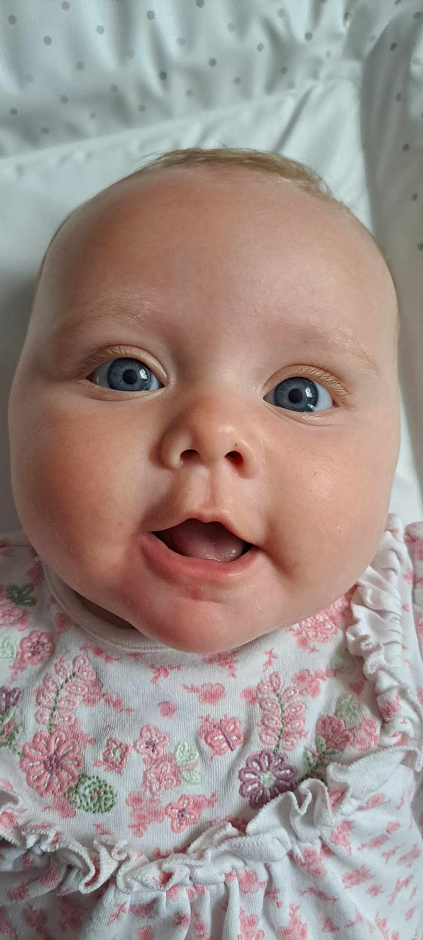 Arianwen joined the competition — help win amazing prizes! baby, infant, face, blue_eyes, open_mouth, cute, closeup, clothing, floral_pattern, white_outfit, polka_dot, blanket, child, portrait, skin, head, person, smile, young, expression