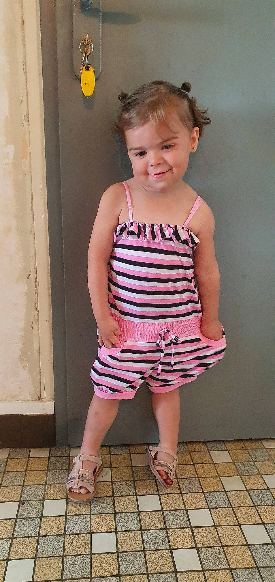 Inaya participe au concours pour gagner de l'argent avec cette photo : baby_toddler_clothing, clothing, door, face, hair, joint, joy, leg, neck, pattern, person, pink, shoulder, sleeve, smile, standing, t_shirt, thigh, toddler, waist