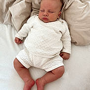 Louis a rejoint le concours — aidez-le/la à gagner de superbes lots ! baby, sleeping, knitted_clothing, white_outfit, blanket, soft_texture, infant, peaceful, cozy, cute, resting, newborn, indoors, relaxation, portrait, child, skin, hand, foot, head