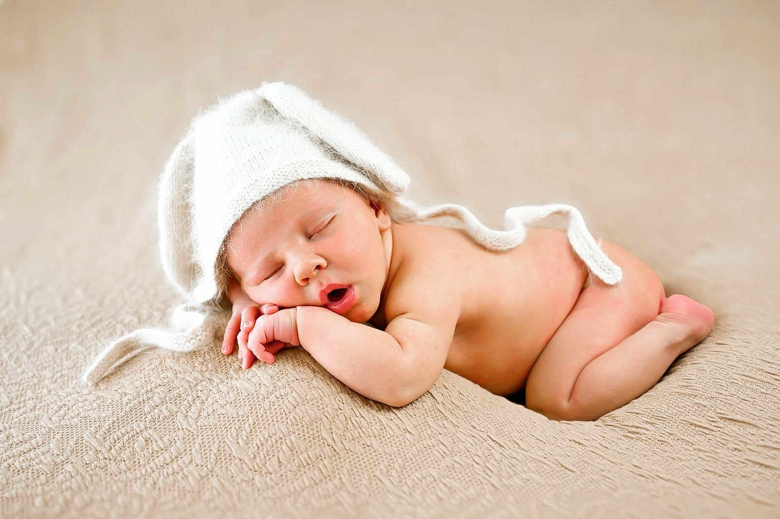 Louis participe au concours pour gagner de l'argent avec cette photo : baby, newborn, sleeping, hat, knitted_hat, blanket, beige, cute, infant, peaceful, resting, soft_texture, skin, closed_eyes, hand, face, headwear, toddler, portrait, lying_down