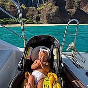 Mailehea is registered to the contest to win money with this photo: adventure, baby, boat, car_seat, cliffs, happy, headband, infant, nature, ocean, outdoor, rocks, seat, smiling, summer, sunlight, towel, travel, vacation, water