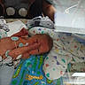 newborn, baby, incubator, hospital, medical_equipment, blanket, animal_print, heart_pattern, monitoring_wires, tiny, premature, swaddled, infant, healthcare, child, bed, nurse_arm, care, patient, neonatal