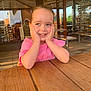 Ambre a rejoint le concours — aidez-le/la à gagner de superbes lots ! cafe, casual, child, cute, daylight, expression, face, girl, hands, happy, leisure, outdoor, people, pink_shirt, portrait, seat, smiling, sunlight, wooden_table, young