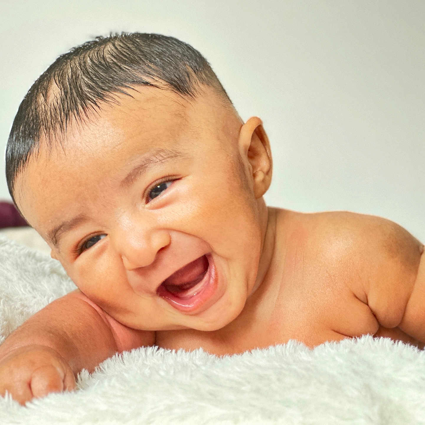 Riyaan joined the competition — help win amazing prizes! baby, bare_skin, blanket, cheerful, child, closeup, cute, expression, face, fun, hair, happy, infant, lying_down, portrait, skin, smiling, soft_texture, warm, young