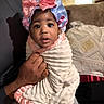 baby, child, infant, portrait, sitting, indoors, couch, blanket, swaddle, bonnet, bow, pink, blue, white, baby_clothing, adult_hand, face, wide_eyed, home, photography