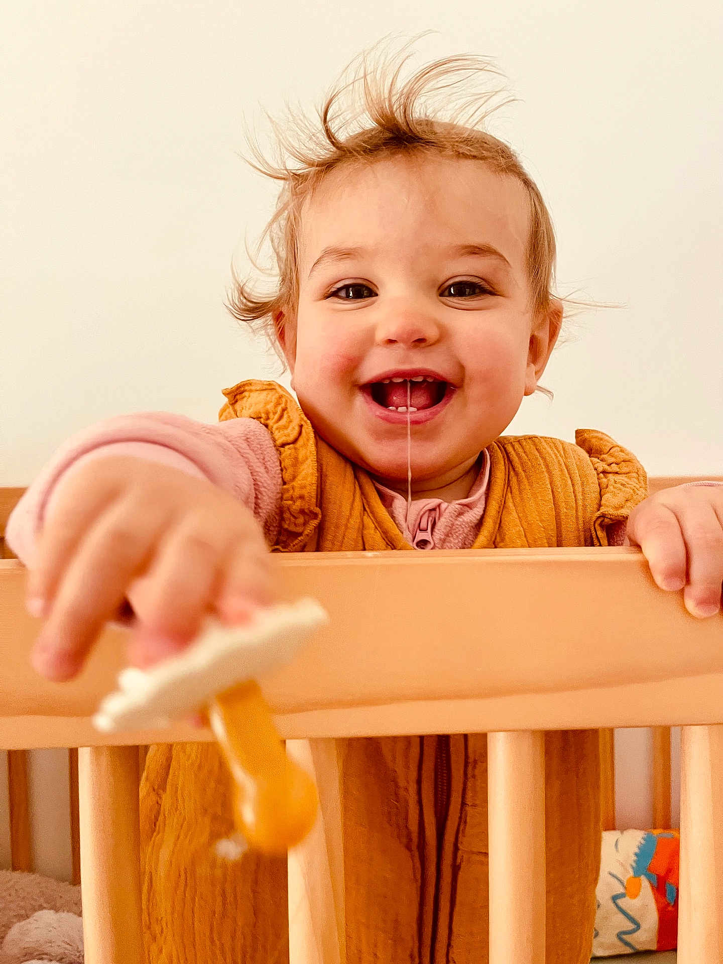 Victoire participe au concours pour gagner de l'argent avec cette photo : toddler, child, baby, smiling, drool, pacifier, crib, wooden_crib, clothing, indoor, happy, face, hand, hair, person, portrait, toy, infant, cute, playful