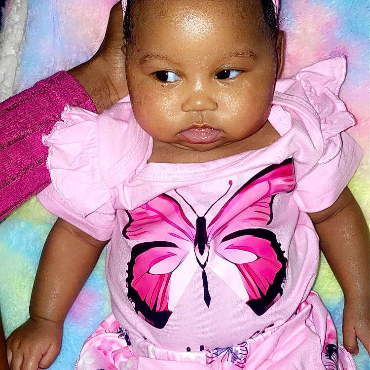 Khalyla joined the competition — help win amazing prizes! baby, blanket, bow, butterfly, child, colorful_background, cute, expression, hand, headband, indoors, infant, person, pink_clothing, portrait, ruffles, sitting, skin, soft_texture, young