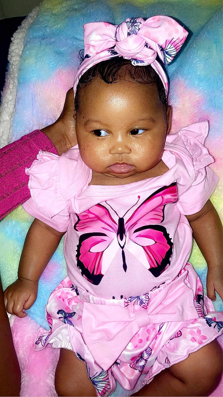 Khalyla joined the competition — help win amazing prizes! baby, infant, child, pink_clothing, butterfly, headband, blanket, hand, cute, portrait, soft_texture, colorful_background, sitting, ruffles, bow, skin, expression, indoors, person, young