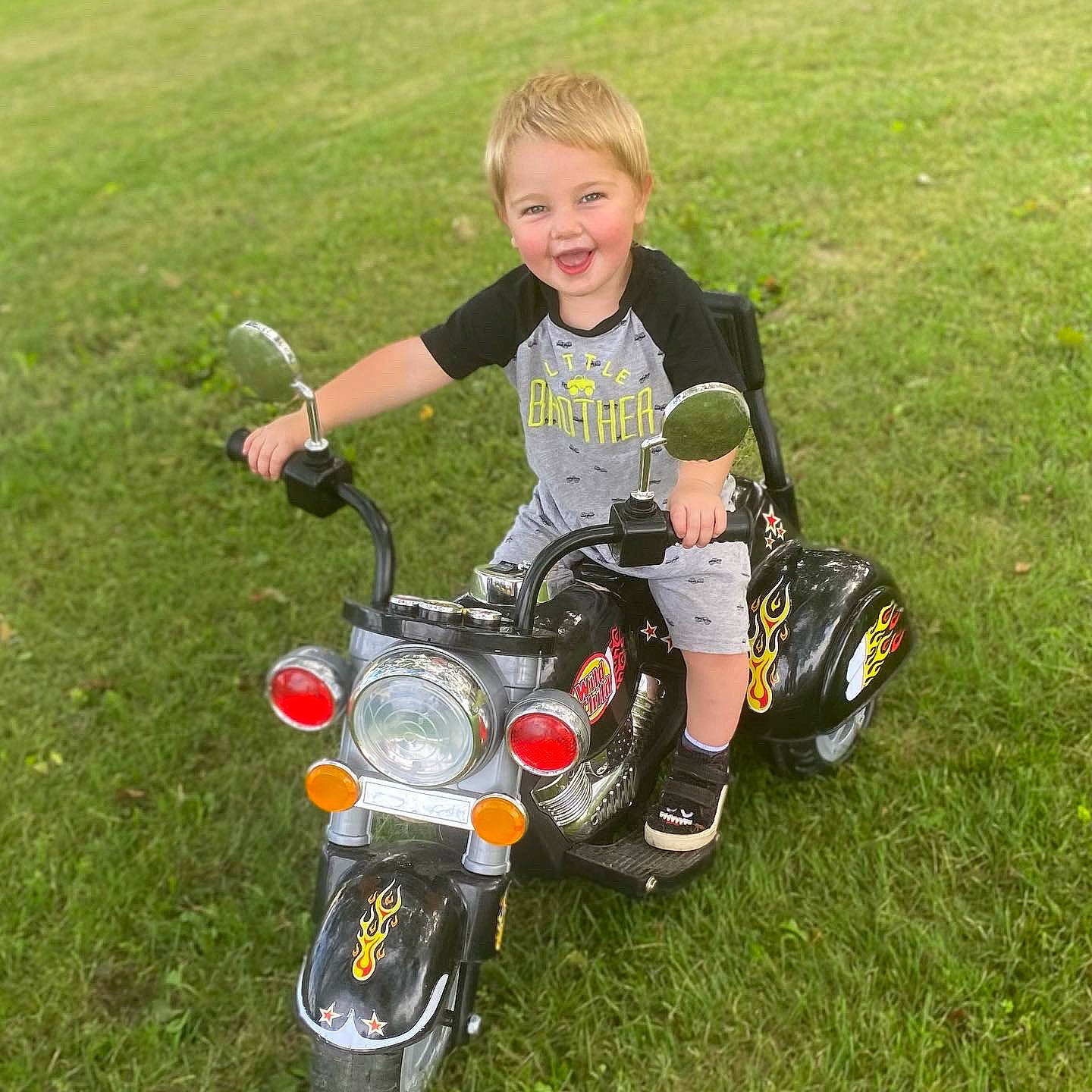 Cayde is registered to the contest to win money with this photo: automotive_design, automotive_exterior, automotive_lighting, automotive_tire, automotive_wheel_system, fender, fuel_tank, grass, headlamp, joy, lawn, motor_vehicle, motorcycle, motorcycle_accessories, person, plant, rim, smile, tire, toddler