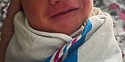 Azazel is registered to the contest to win money with this photo: newborn, baby, smile, blanket, swaddled, face, infant, hand, fabric, hospital, portrait, sleepy, cute, soft, closeup, person, bed, comfort, rest, child