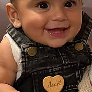 Asaël a rejoint le concours — aidez-le/la à gagner de superbes lots ! baby, child, smile, face, denim_overalls, hand, happy, cute, infant, holding_hand, portrait, skin, clothing, person, closeup, cheerful, young, indoor, expression, human