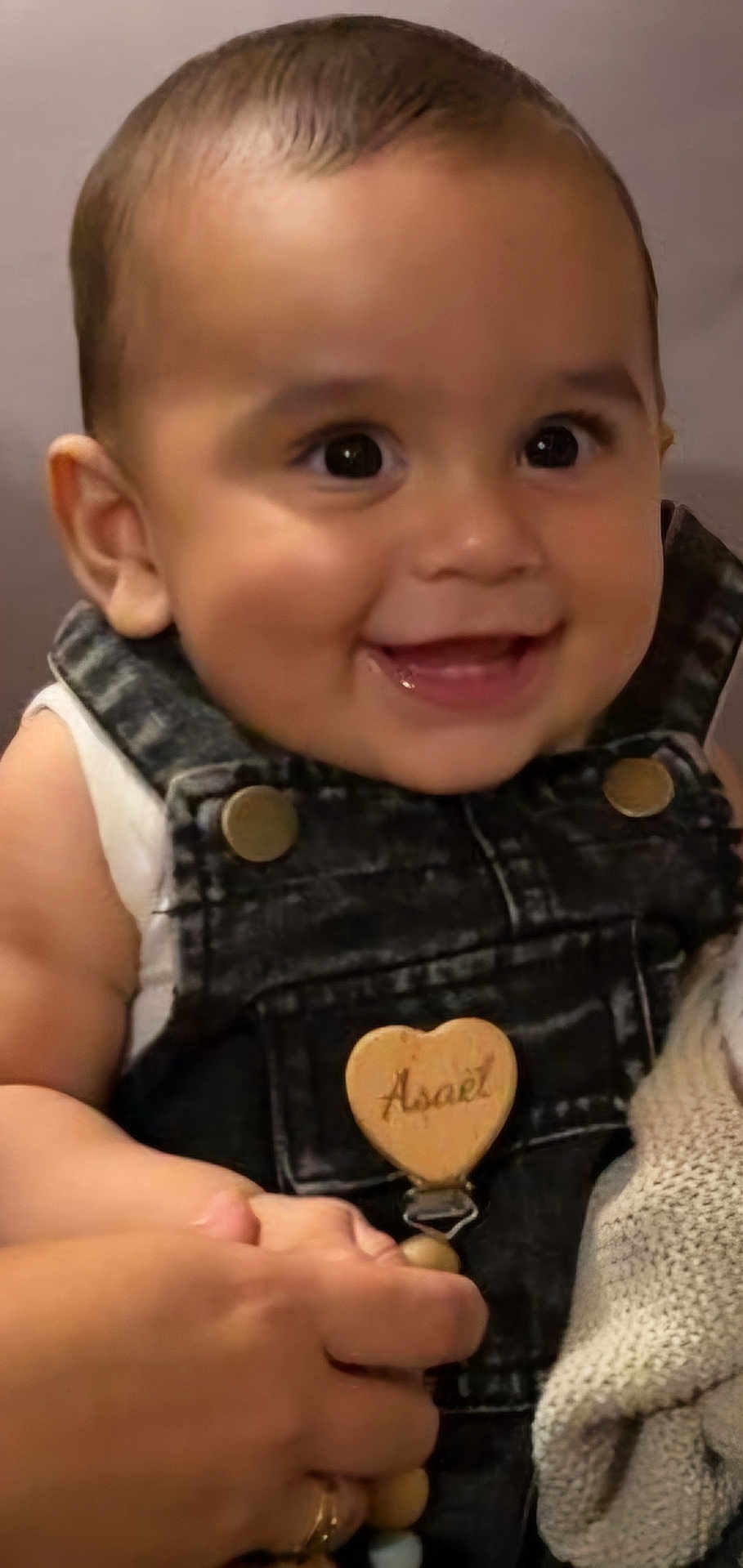 Asaël a rejoint le concours — aidez-le/la à gagner de superbes lots ! baby, child, smile, face, denim_overalls, hand, happy, cute, infant, holding_hand, portrait, skin, clothing, person, closeup, cheerful, young, indoor, expression, human