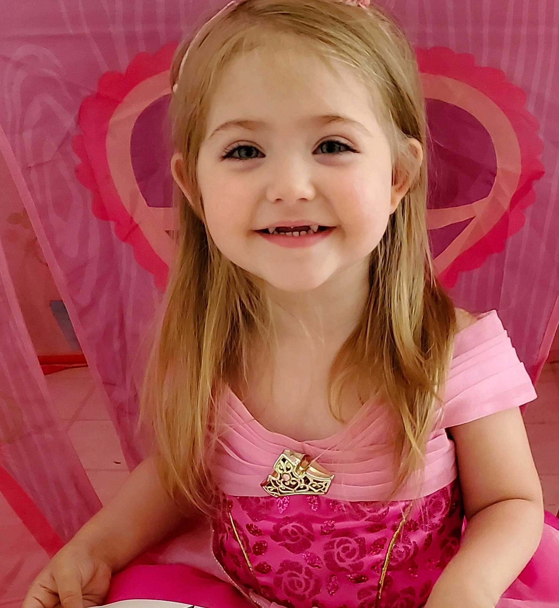 Aaliyah is registered to the contest to win money with this photo: blond, cheek, ear, eyelash, face, hair, hairstyle, happy, iris, joy, lip, long_hair, magenta, mouth, neck, person, pink, sleeve, smile, t_shirt