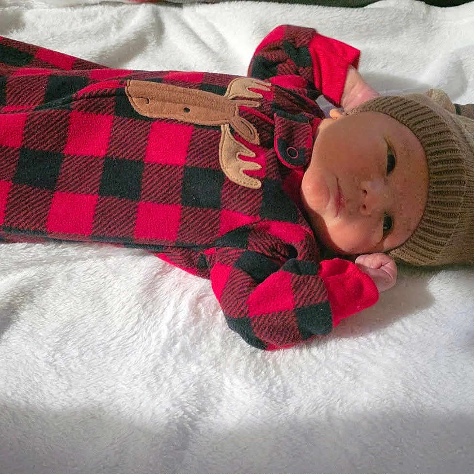 Attikus joined the competition — help win amazing prizes! baby, baby_clothing, black, blanket, brown, child, cozy, cute, face, hat, indoor, infant, knit_hat, lying_down, newborn, onesie, plaid_pattern, portrait, red, soft_texture