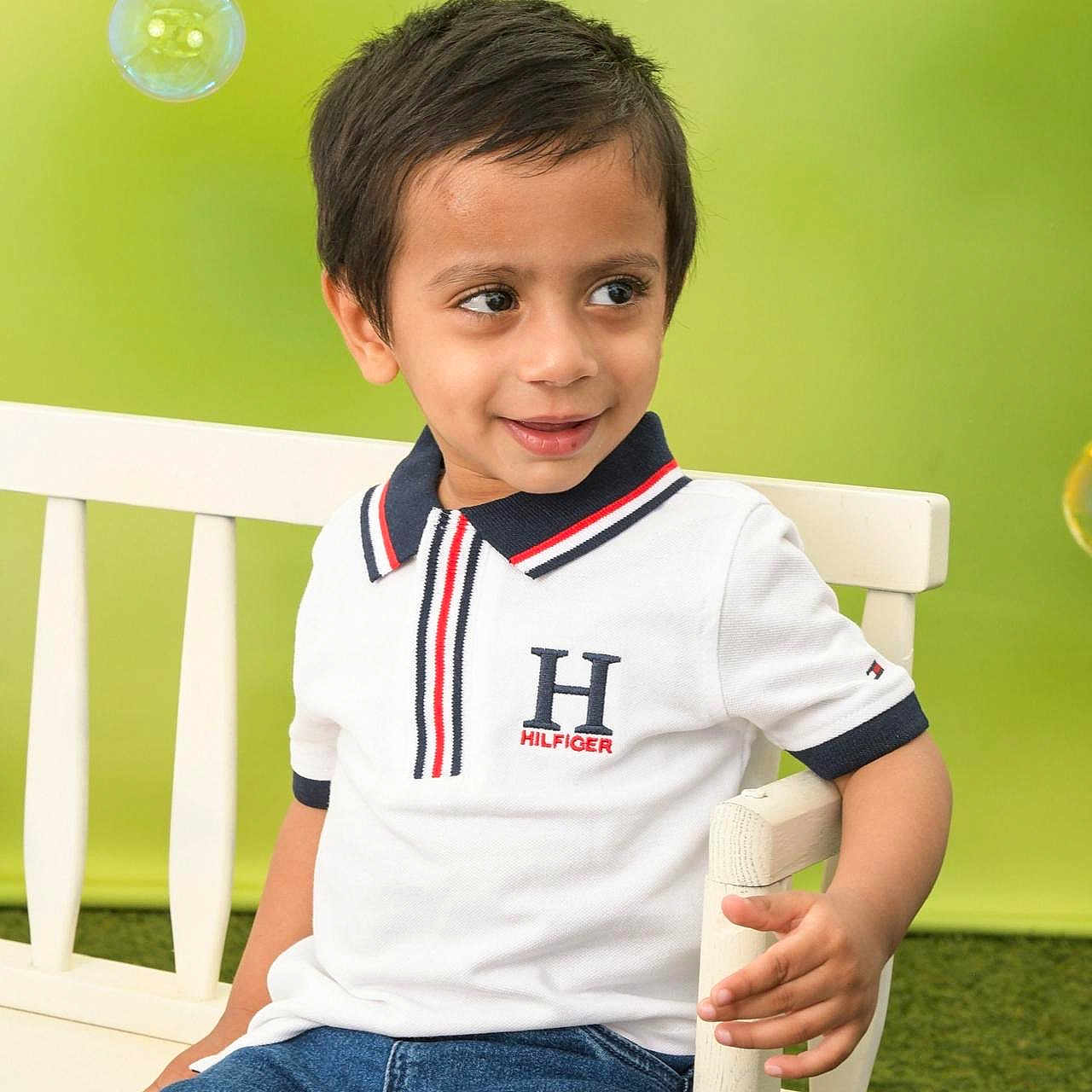 Shivaan is registered to the contest to win money with this photo: blue_jeans, boy, bubble, casual_clothing, chair, child, cute, fashion, green_background, happy, indoor, people, person, playful, portrait, short_hair, sitting, smile, white_polo_shirt, young_child