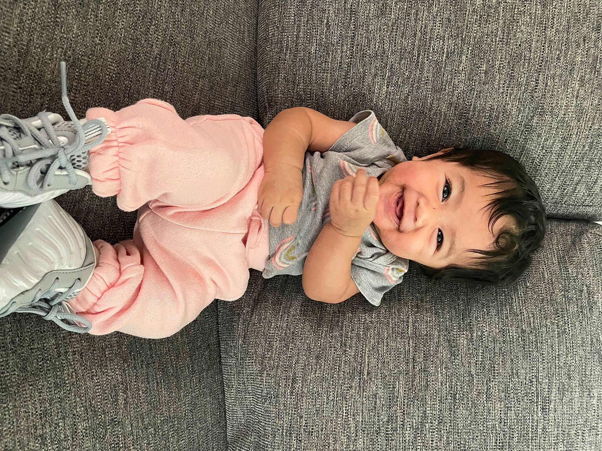 Micah is registered to the contest to win money with this photo: baby, baby_toddler_clothing, cheek, child, comfort, flooring, foot, fun, grass, human_leg, lap, linens, person, plant, room, sitting, skin, smile, textile, toddler