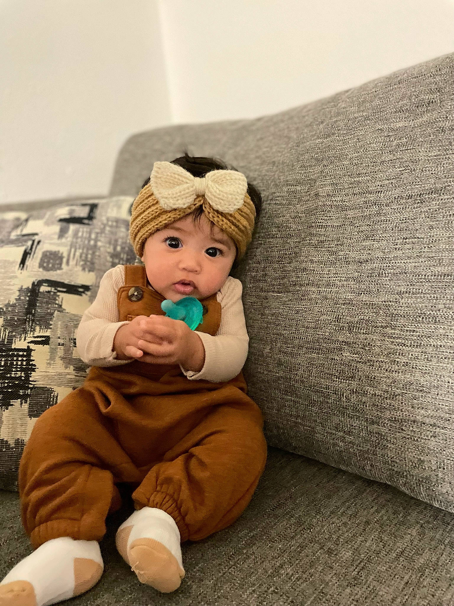 Micah joined the competition — help win amazing prizes! baby, cap, child, comfort, couch, fashion_accessory, flooring, foot, fur, happy, hat, headwear, human_leg, linens, person, pillow, room, sitting, t_shirt, textile
