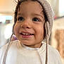 toddler, child, smiling, hat, knit_hat, ear_flaps, sweatshirt, animal_print, cheetah, face, eyes, indoor, soft_light, portrait, happy, cute, young_child, clothing, closeup, person