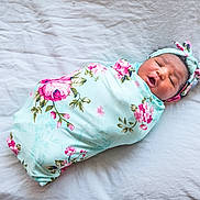 Keonna Kwe is registered to the contest to win money with this photo: baby, newborn, swaddled, blanket, floral, headband, infant, sleeping, cute, soft, white_background, child, person, portrait, newborn_baby, cozy, lying_down, peaceful, wrapped, toddler