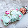 baby, newborn, swaddled, blanket, floral, headband, infant, sleeping, cute, soft, white_background, child, person, portrait, newborn_baby, cozy, lying_down, peaceful, wrapped, toddler