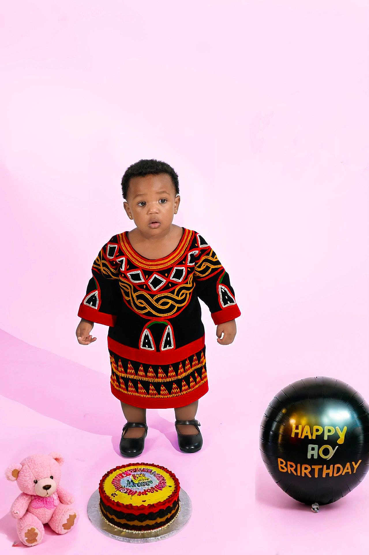 Keonna Kwe is registered to the contest to win money with this photo: child, toddler, birthday, cake, balloon, teddy_bear, traditional_clothing, pink_background, shoes, portrait, celebration, colorful, studio_photo, standing, cute, indoors, smile, face, person, holiday