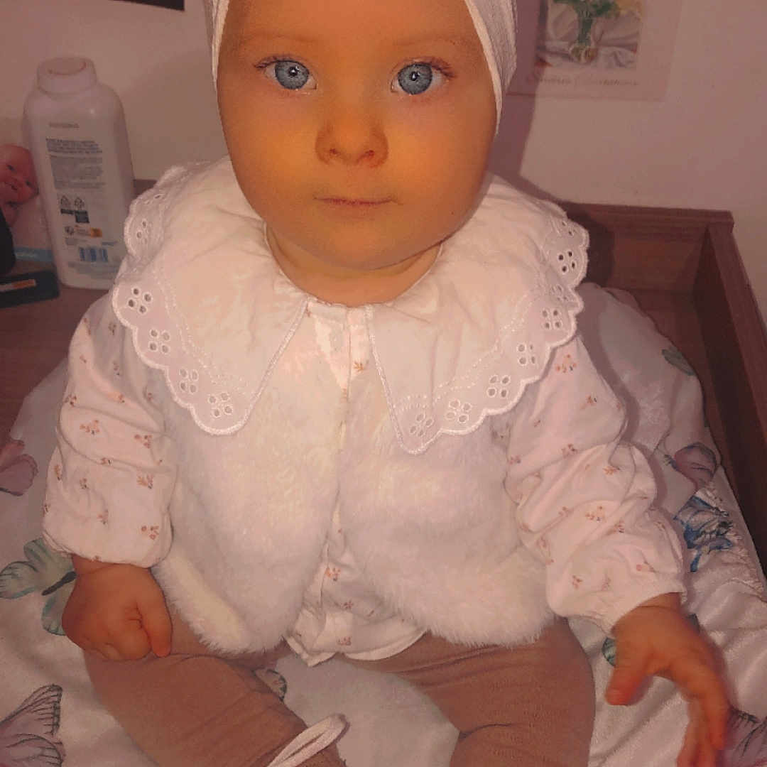 Tina participe au concours pour gagner de l'argent avec cette photo : baby, bed, bonnet, clothing, couch, doll, dress, face, footwear, furniture, hat, head, homedecor, linen, person, photography, portrait, shoe, sitting, toy
