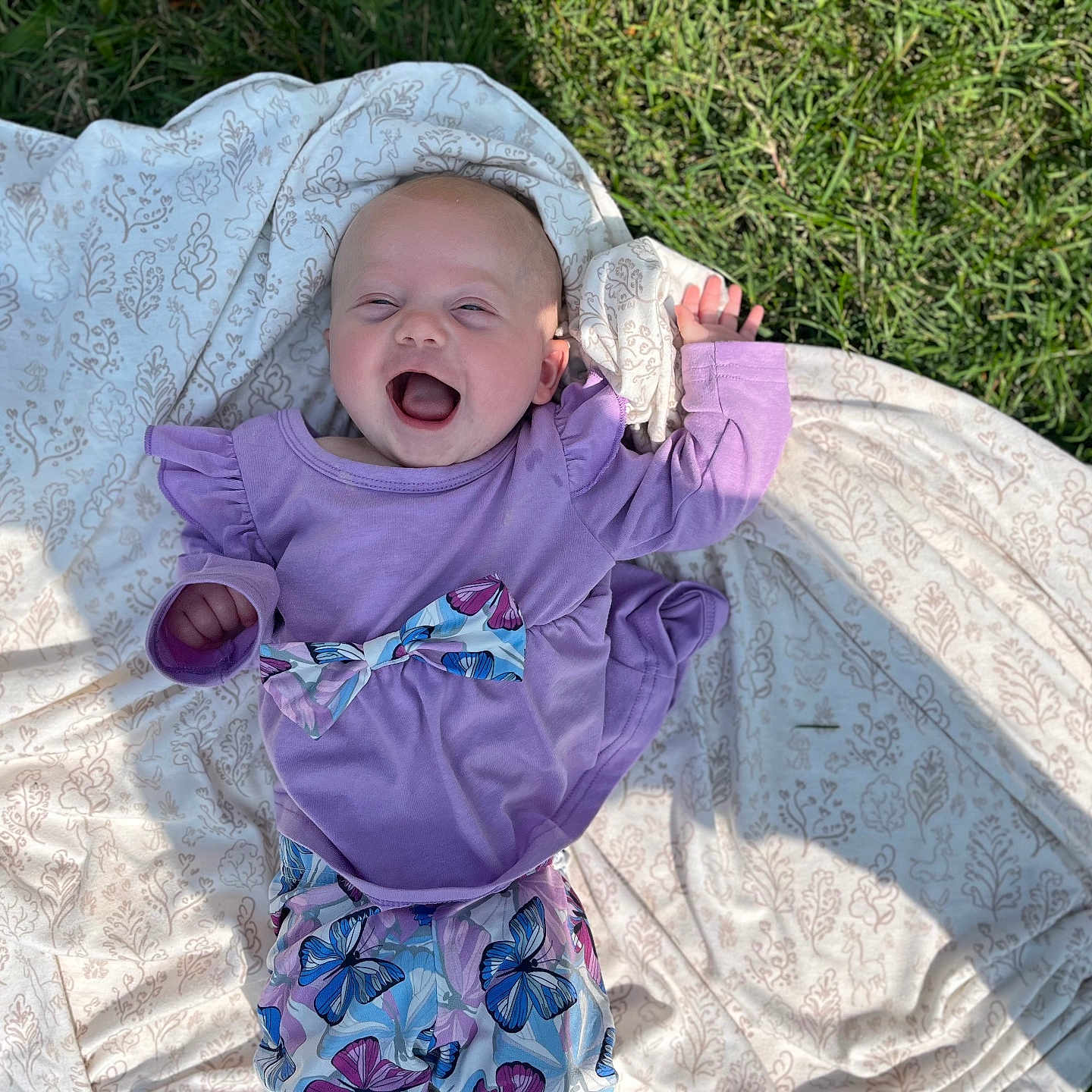 Anastasia is registered to the contest to win money with this photo: baby, blanket, bonnet, clothing, dress, face, grass, happy, hat, head, laughing, longsleeve, person, photography, plant, portrait, purple, quilt, sleeve, t_shirt
