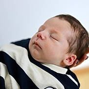 Elio participe au concours pour gagner de l'argent avec cette photo : newborn, baby, sleeping, infant, face, hand, clothing, striped, closeup, portrait, peaceful, soft_focus, skin, head, person, young_child, indoor, resting, tender, cute