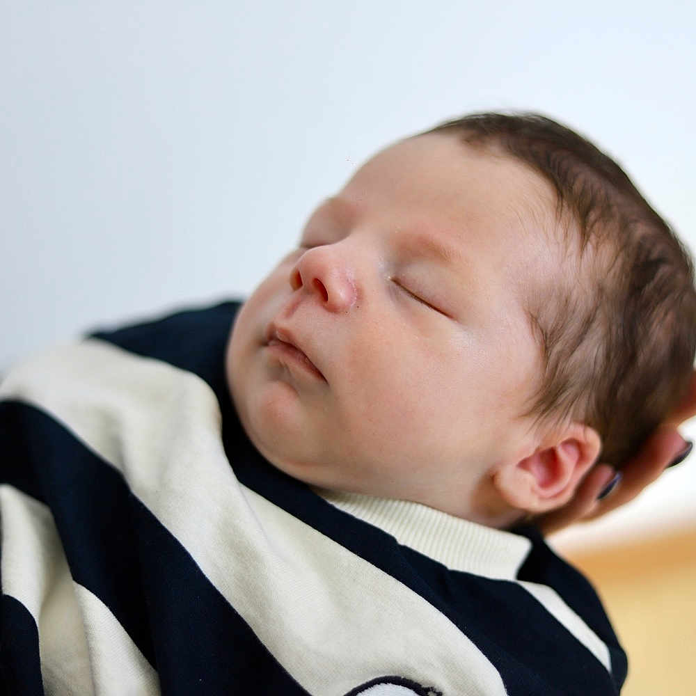 Elio participe au concours pour gagner de l'argent avec cette photo : newborn, baby, sleeping, infant, face, hand, clothing, striped, closeup, portrait, peaceful, soft_focus, skin, head, person, young_child, indoor, resting, tender, cute