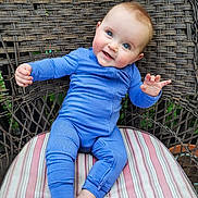 Jolie joined the competition — help win amazing prizes! baby, child, blue_onesie, smile, happy, sitting, striped_cushion, wicker_chair, outdoor, cute, infant, portrait, barefoot, face, person, young_child, expression, natural_light, skin, head