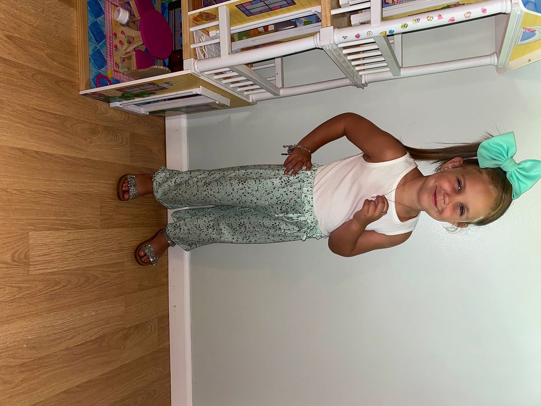 Oaklee is registered to the contest to win money with this photo: book, bookcase, comfort, elbow, flooring, happy, hardwood, hat, human_leg, joy, knee, person, publication, room, shelf, shelving, smile, stairs, thigh, waist