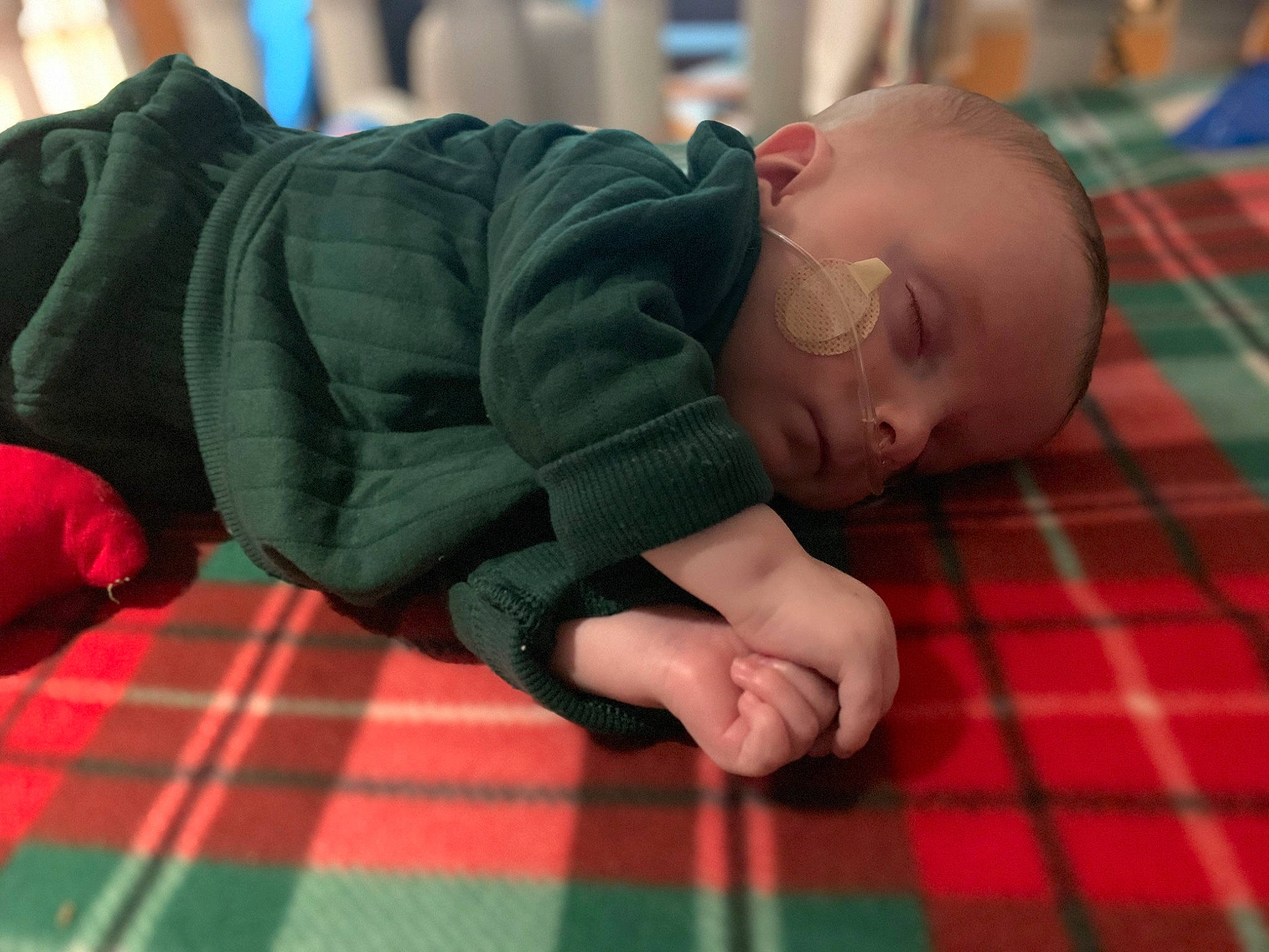 Thor is registered to the contest to win money with this photo: baby, baby_toddler_clothing, cheek, chest, child, comfort, elbow, finger, flooring, fun, grass, linens, pattern, person, plaid, room, sitting, tartan, thumb, toddler
