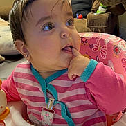 Lara joined the competition — help win amazing prizes! baby, child, infant, sitting, activity_seat, pink_clothing, striped_shirt, curious, face, eyes, finger, hand, indoor, home, furniture, chair, toy, colorful, portrait, happy